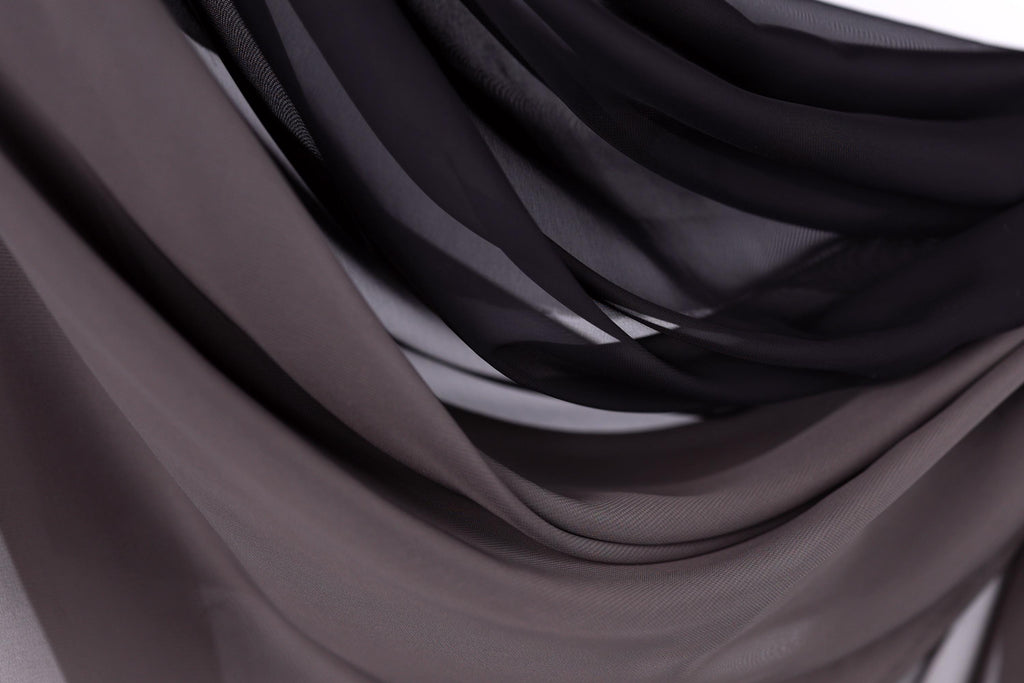 a close-up view of a fabric with a dark gray or black color scheme, creating a sense of depth and texture.