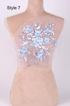 A mannequin with a floral design on its back, featuring blue and white flowers and leaves.