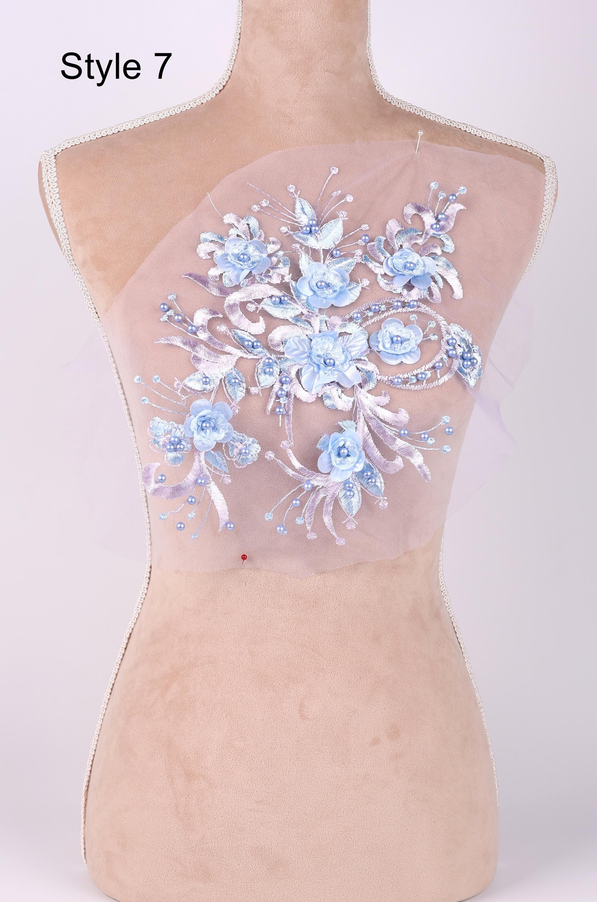 A mannequin with a floral design on its back, featuring blue and white flowers and leaves.