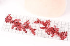 a ruler with red sequin designs on it, placed on a white surface.