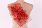 a mannequin torso with a red, floral-patterned fabric or material attached to it, possibly as a decorative piece or embellishment.