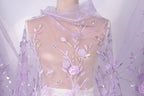 A mannequin wearing a sheer, lavender-colored dress with delicate floral embroidery.