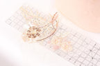 a close-up view of a clear ruler with various decorative elements, including a flower-shaped object and a butterfly-shaped object, placed on a white surface.