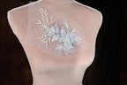 A mannequin with a delicate floral embroidered on its chest.
