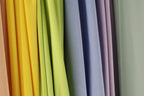 A row of colorful fabric swatches in various shades of yellow, green, blue, and purple.