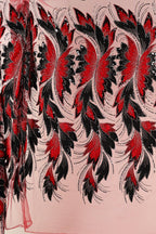 a close-up view of a fabric with a striking floral pattern in red and black. The pattern consists of numerous red flowers with black leaves, creating a visually captivating design. The fabric appears to be a sheer material, allowing the intricate details of the floral pattern to be clearly visible.