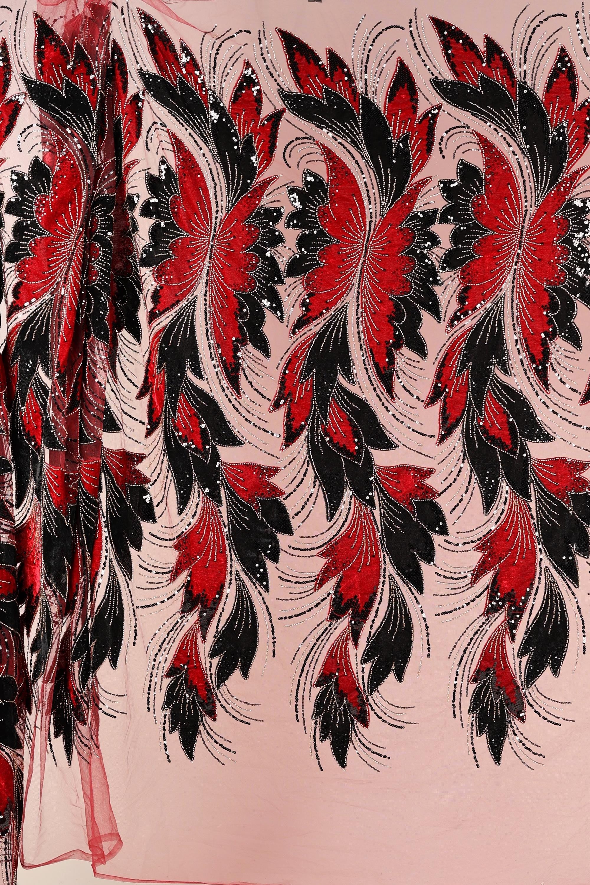 a close-up view of a fabric with a striking floral pattern in red and black. The pattern consists of numerous red flowers with black leaves, creating a visually captivating design. The fabric appears to be a sheer material, allowing the intricate details of the floral pattern to be clearly visible.