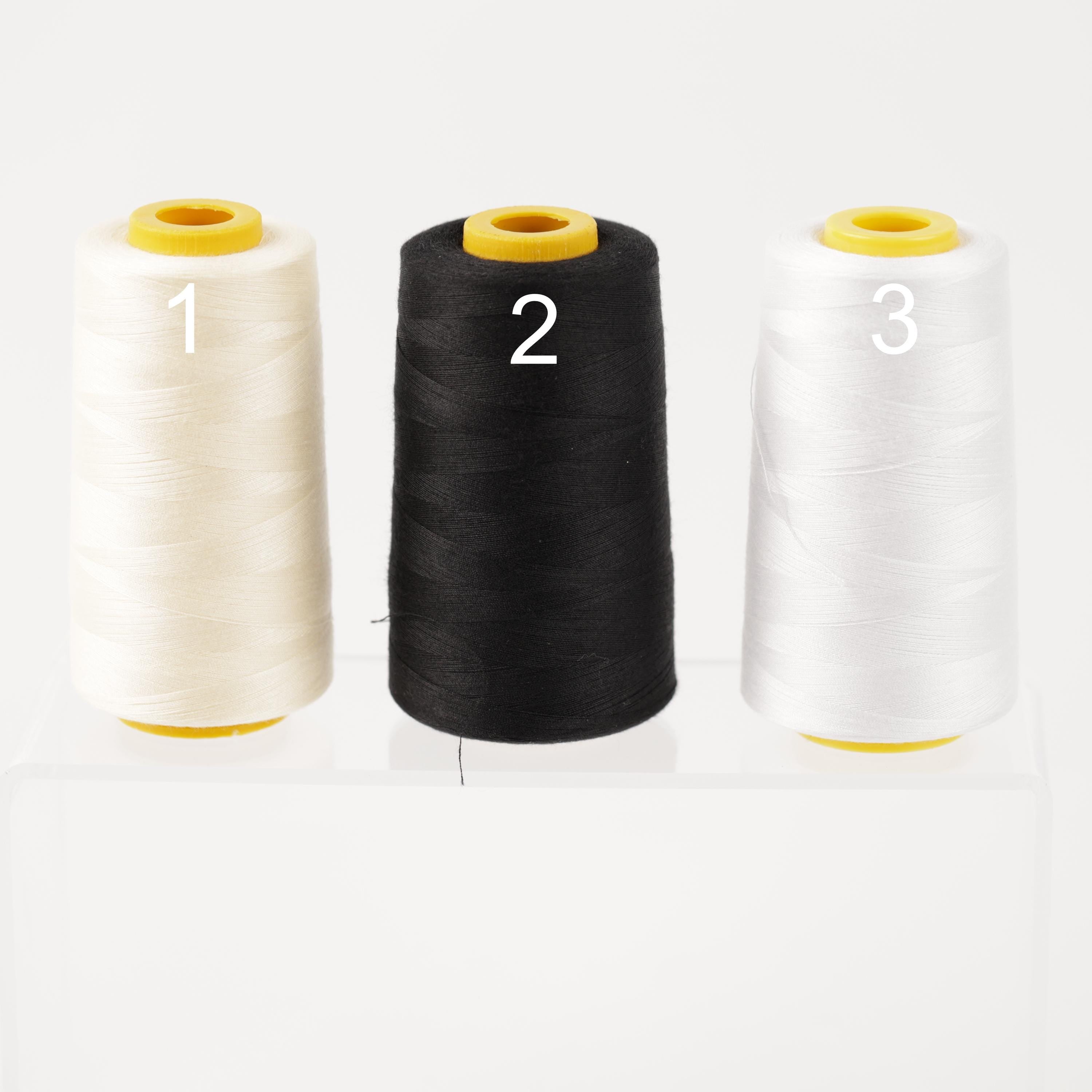 three spools of thread, each with a different color: white, black, and white.