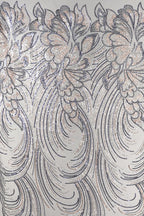 a close-up view of a fabric with a repeating pattern of intricate floral designs in shades of gray and white, accented with gold glitter. The pattern is composed of curved lines and swirls, creating a sense of movement and elegance. The fabric appears to be a type of sheer material, suitable for various applications such as clothing or home decor.
