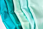 A close-up image of a fabric with a gradient of turquoise to mint colors, creating a visually appealing and vibrant pattern.