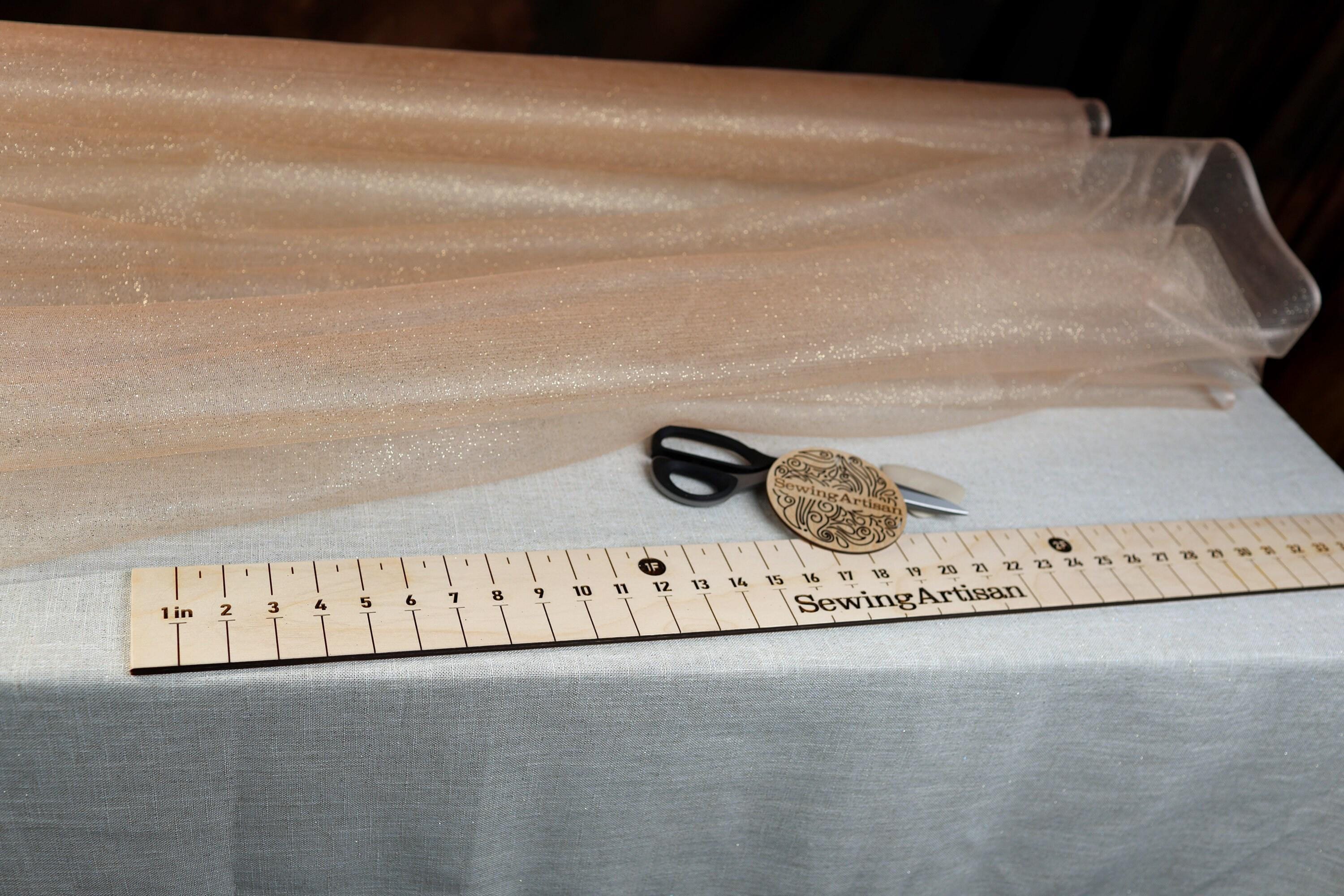 a pair of scissors sitting on top of a ruler