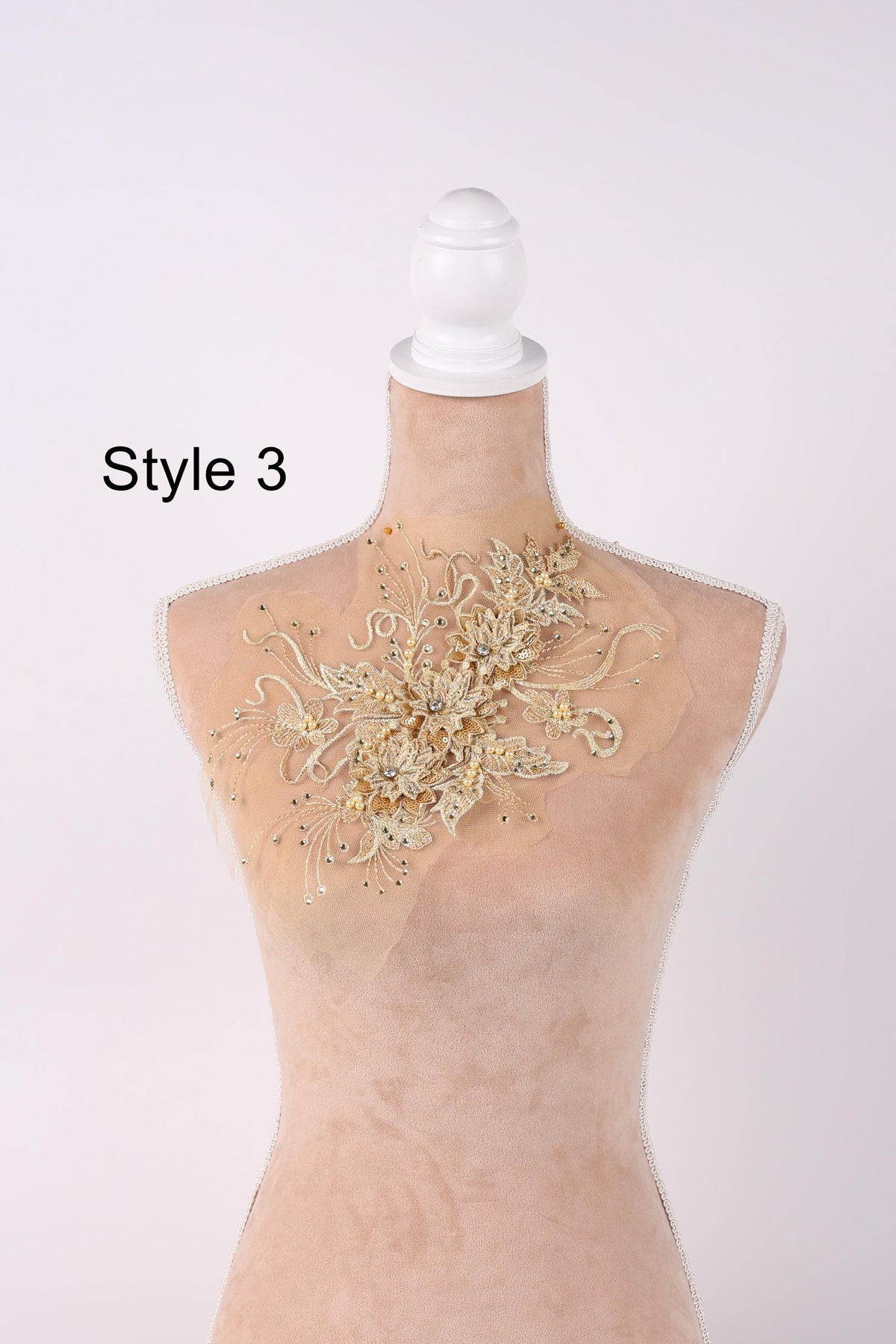 A mannequin with a decorative beaded necklace on its neck.