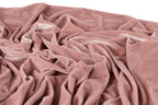 a close-up view of a crumpled, pink velvet fabric.