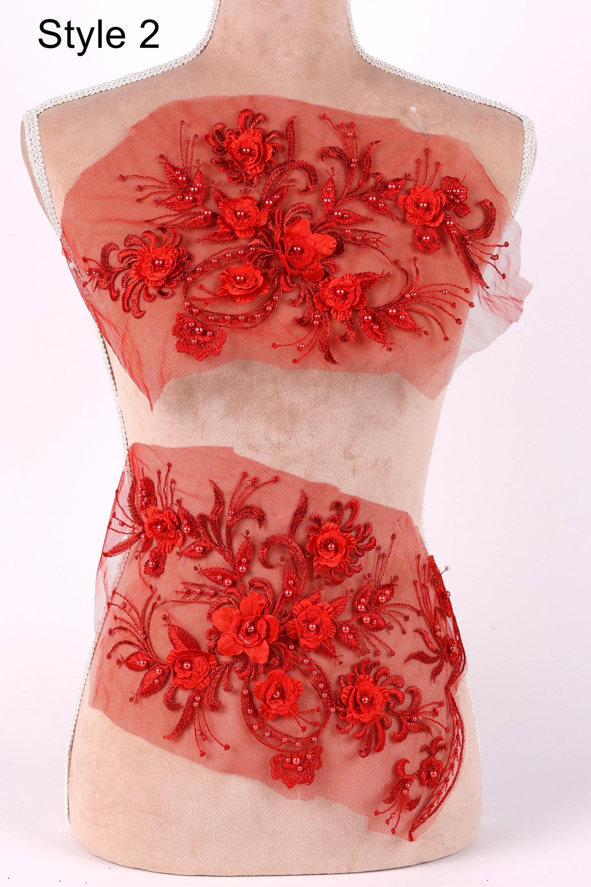 A mannequin wearing a red floral dress with a sheer overlay.