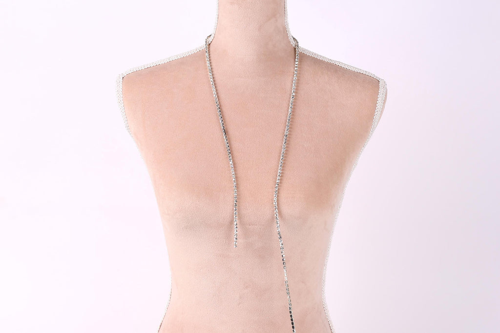 A mannequin wearing a necklace with a long, silver chain.