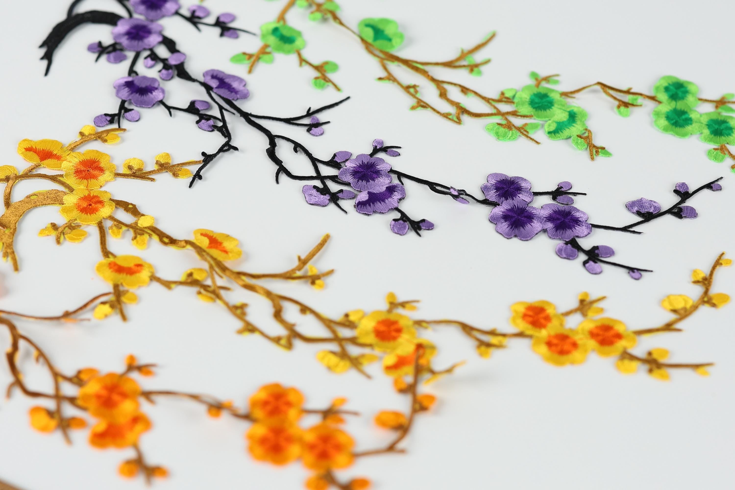 a close-up view of a variety of colorful floral designs, including yellow and orange flowers, purple flowers, and green flowers, arranged in a visually appealing manner.