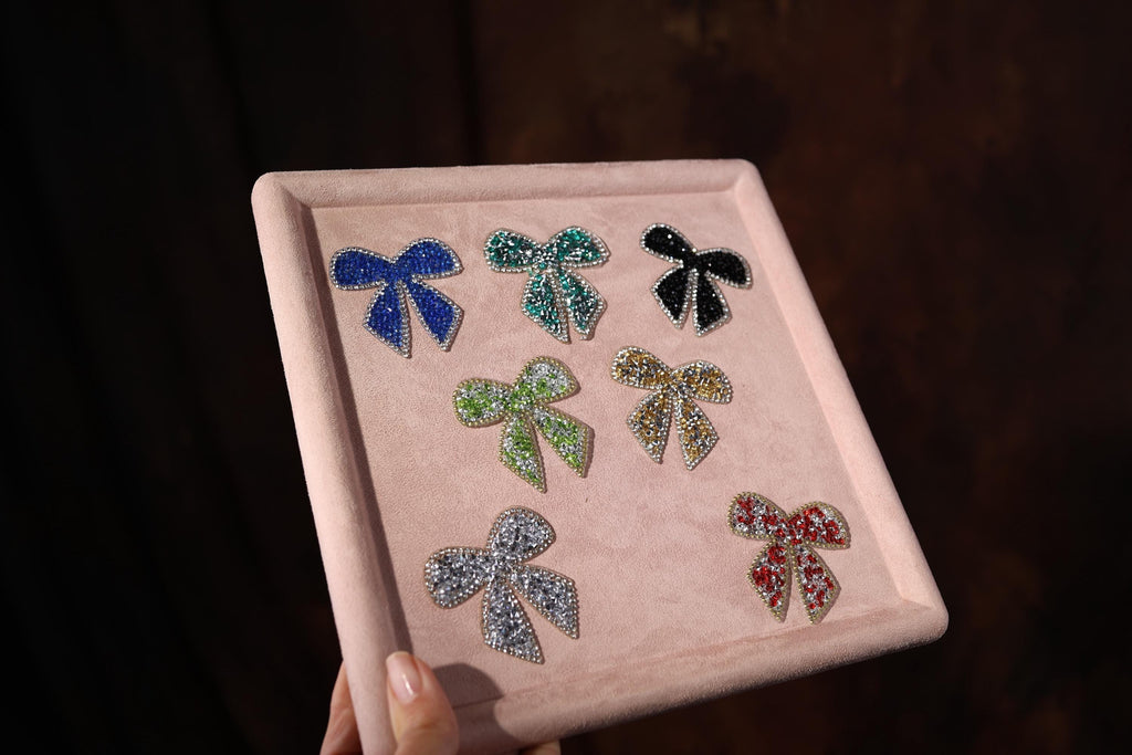 a person holding a tray with different colored bows on it