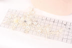 a delicate piece of lace with a flower design, placed on a ruler for scale.