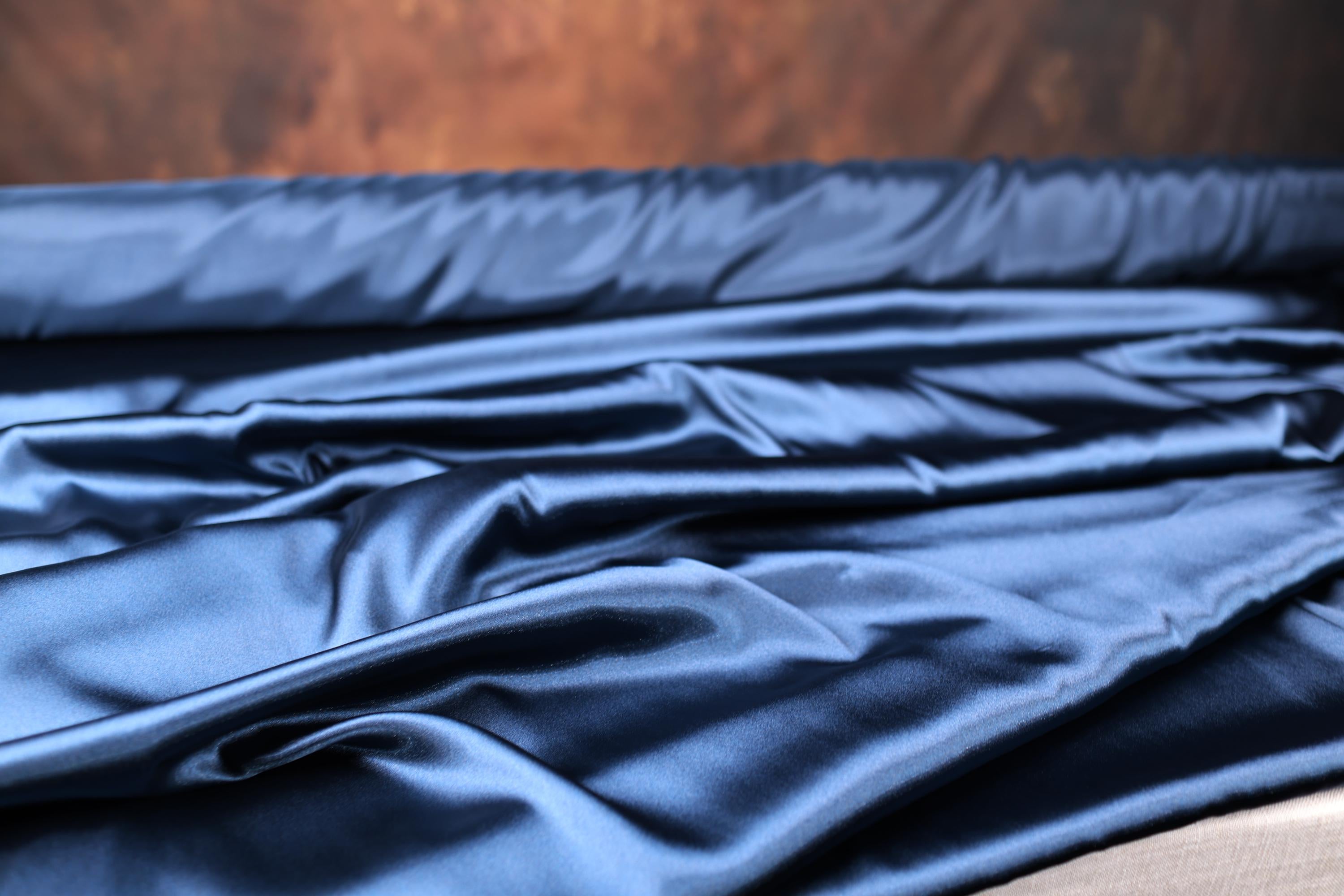 a close up of a blue cloth on a bed