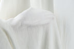 A close-up view of a white fabric, possibly a piece of clothing or a sheer curtain, with a soft, flowing texture.