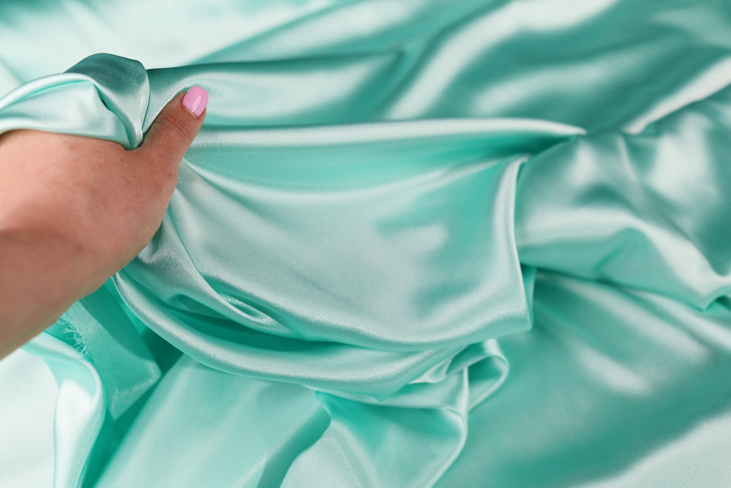 a woman&#39;s hand holding a piece of fabric