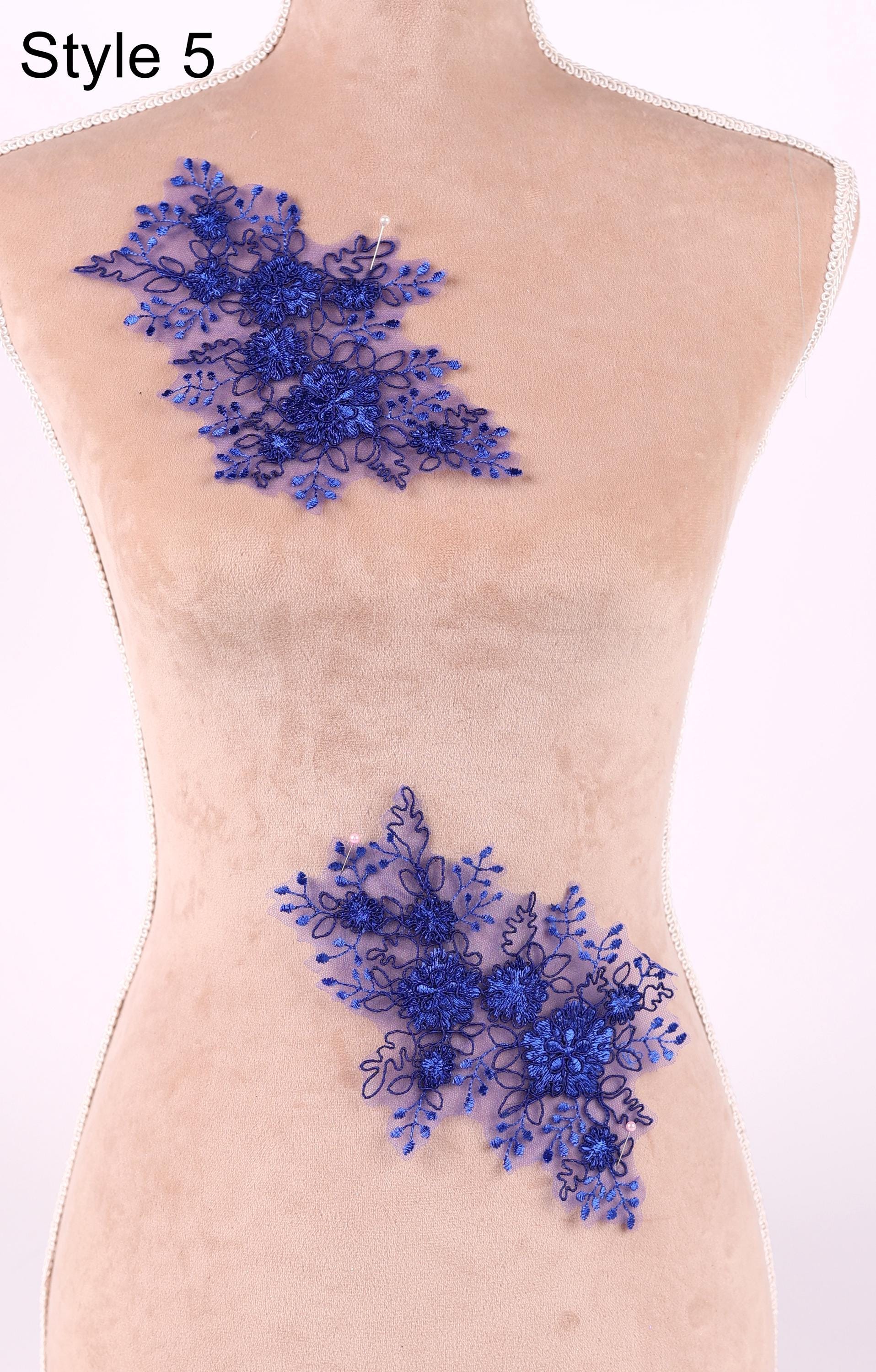 a mannequin with a decorative blue floral lace piece on its bust.