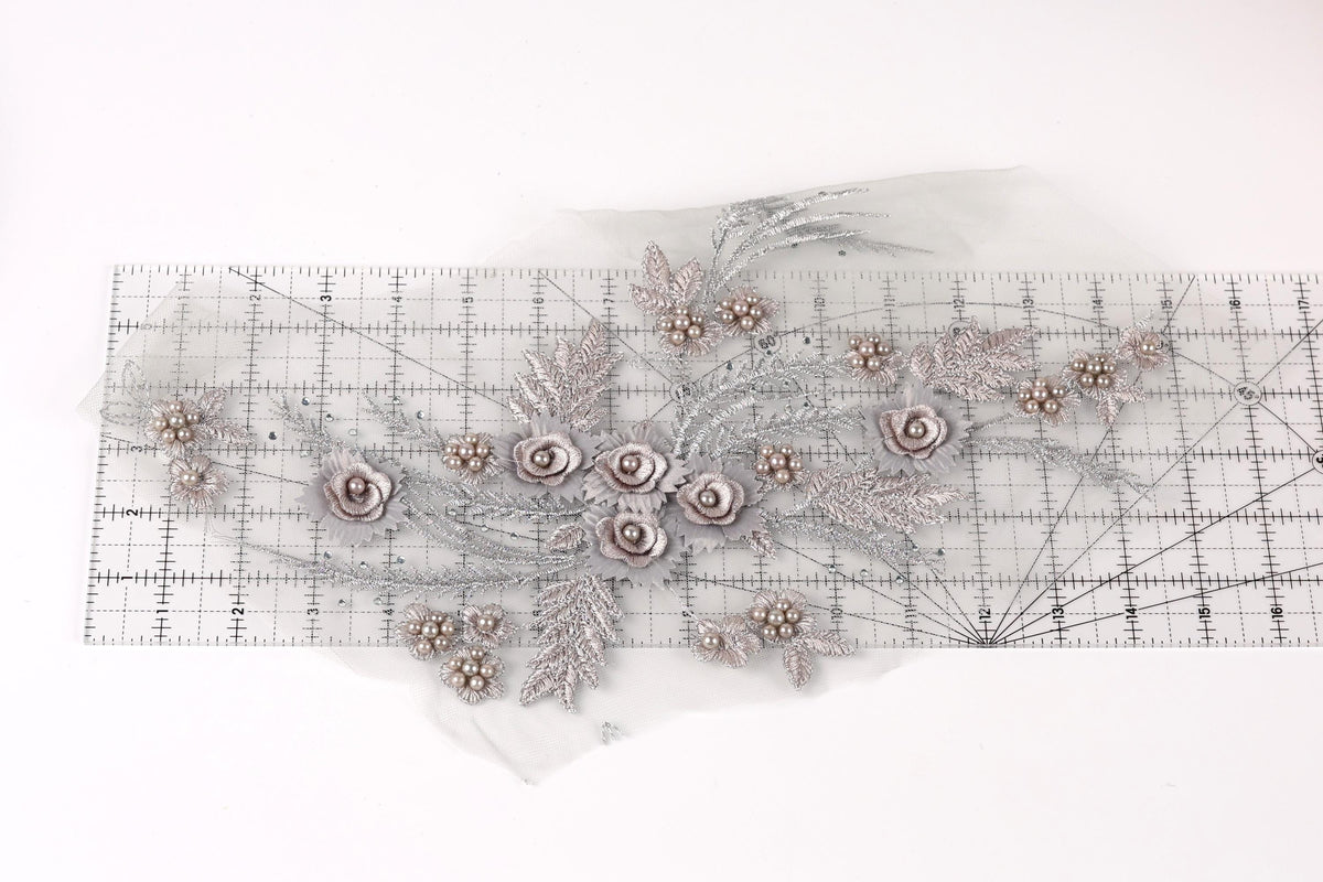 a decorative piece with a floral design, including various flowers and leaves, arranged on a transparent surface.