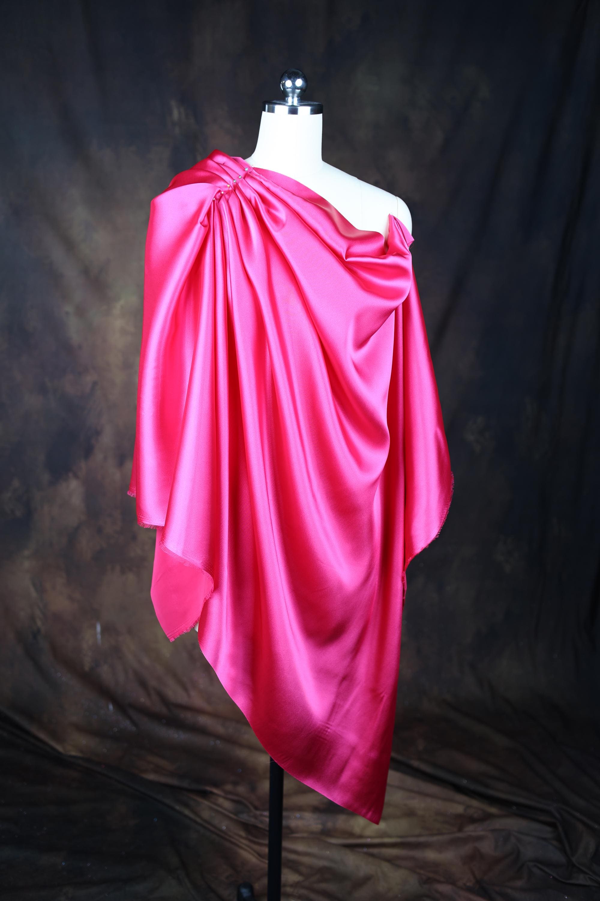 a mannequin wearing a pink draped dress