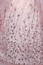 a close-up view of a fabric with a delicate, leaf-like pattern in shades of pink and brown. The fabric appears to be made of sheer material, with a subtle shimmering effect due to the sequins or glitter embedded in the design. The pattern is intricate and detailed, creating a visually appealing and textured appearance.