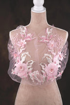A mannequin wearing a dress with a delicate, floral-patterned fabric.