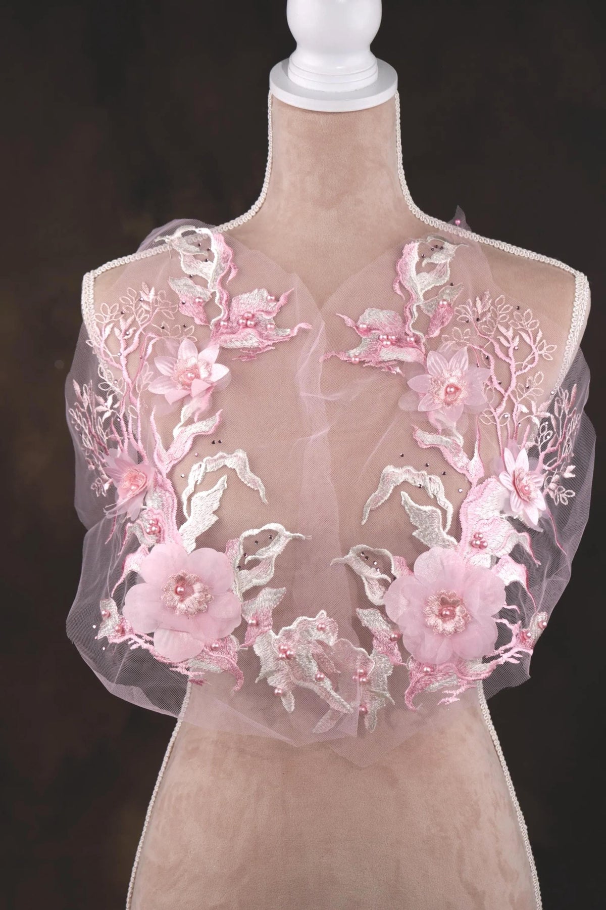 A mannequin wearing a dress with a delicate, floral-patterned fabric.