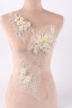 A mannequin torso with three different floral designs sewn onto it.