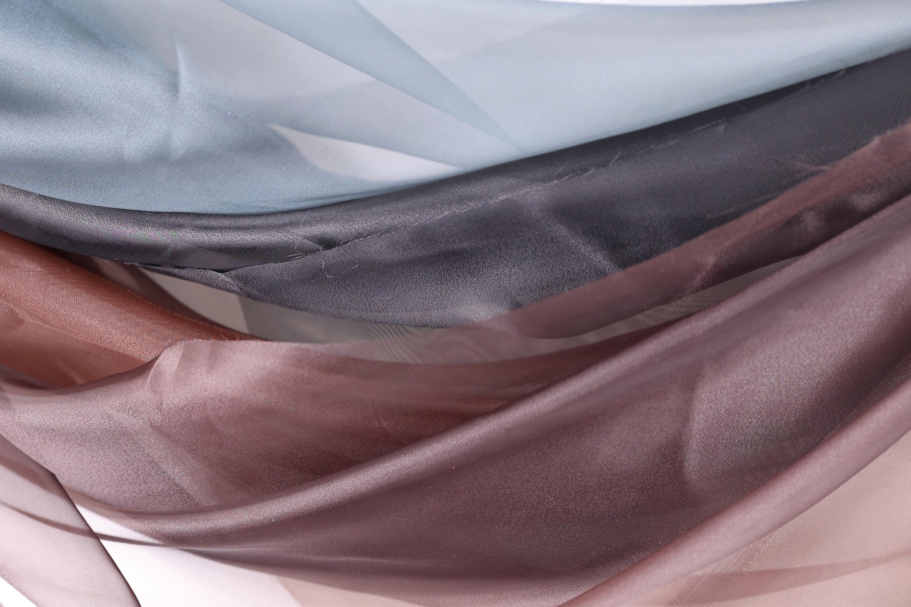 a close-up view of a fabric with a variety of colors and textures, including shades of blue, gray, brown, and pink.