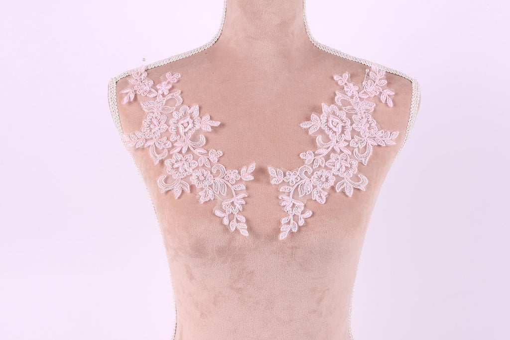 A mannequin with a pink floral lace overlay on its bust area.