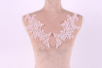 A mannequin with a pink floral lace overlay on its bust area.