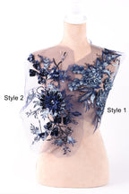 A mannequin wearing a dress with a floral pattern in shades of blue and black.