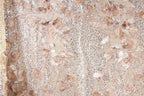 a close-up view of a fabric with a floral pattern, including leaves and flowers. The fabric appears to be made of a shiny, sequined material, giving it a sparkling and elegant appearance.