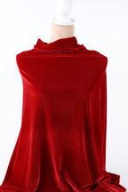 A close-up view of a red velvet fabric, with a white object partially obscuring it.