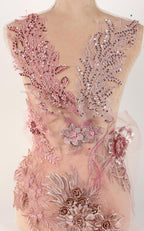 A mannequin wearing a pink and white floral dress with intricate embroidery and sequins.