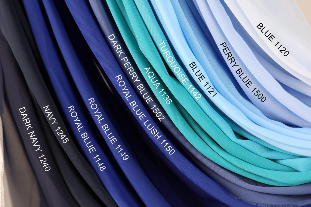 A collection of fabric swatches in various shades of blue, including navy, royal blue, turquoise, aqua, and light blue, arranged in a visually appealing manner.