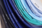 A collection of fabric swatches in various shades of blue, including navy, royal blue, turquoise, aqua, and light blue, arranged in a visually appealing manner.