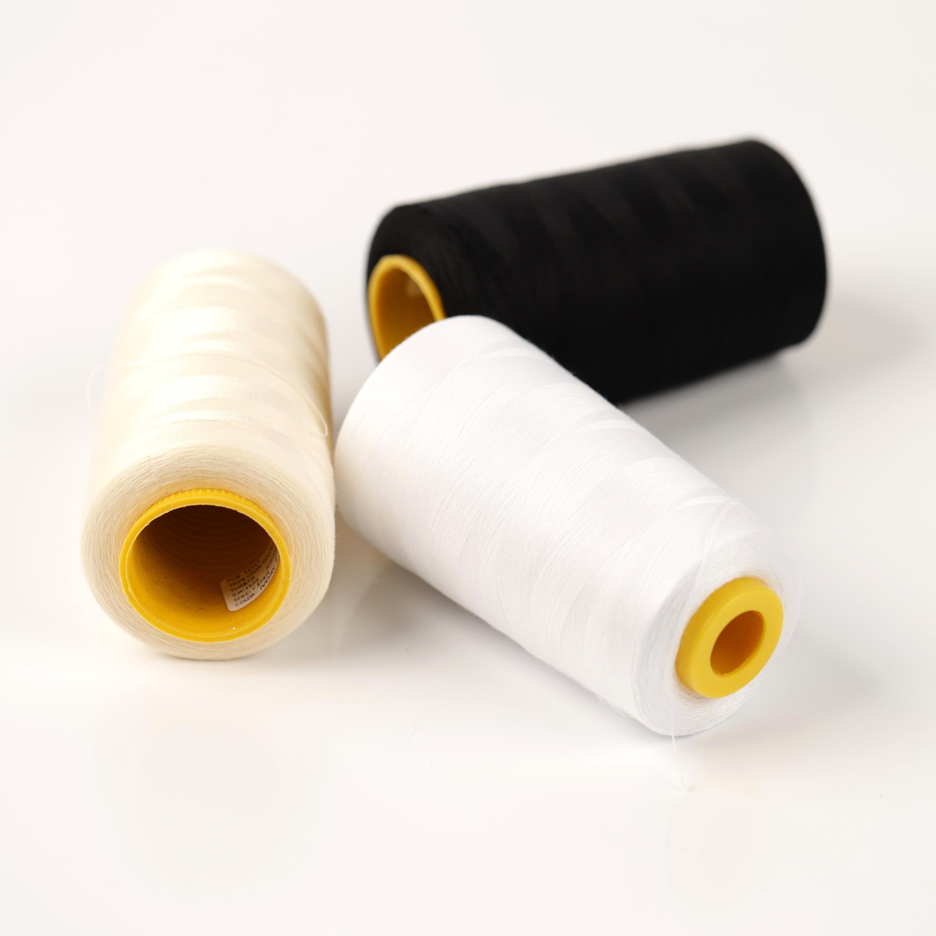 three spools of thread, including white, black, and yellow, arranged on a white background.