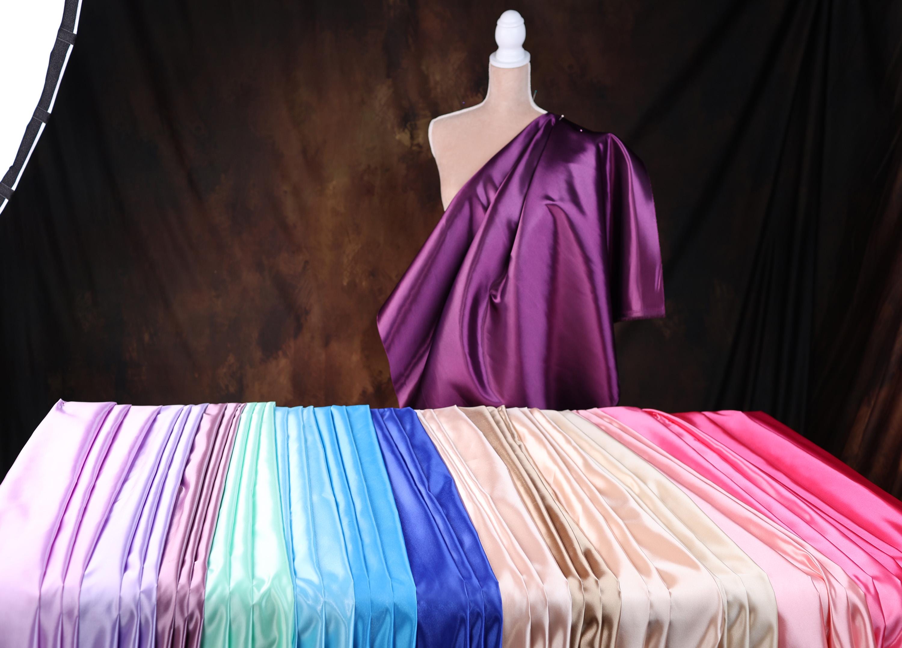 a mannequin is standing next to a row of different colored sheets