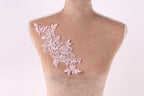 A mannequin with a pink floral lace design on its shoulder.