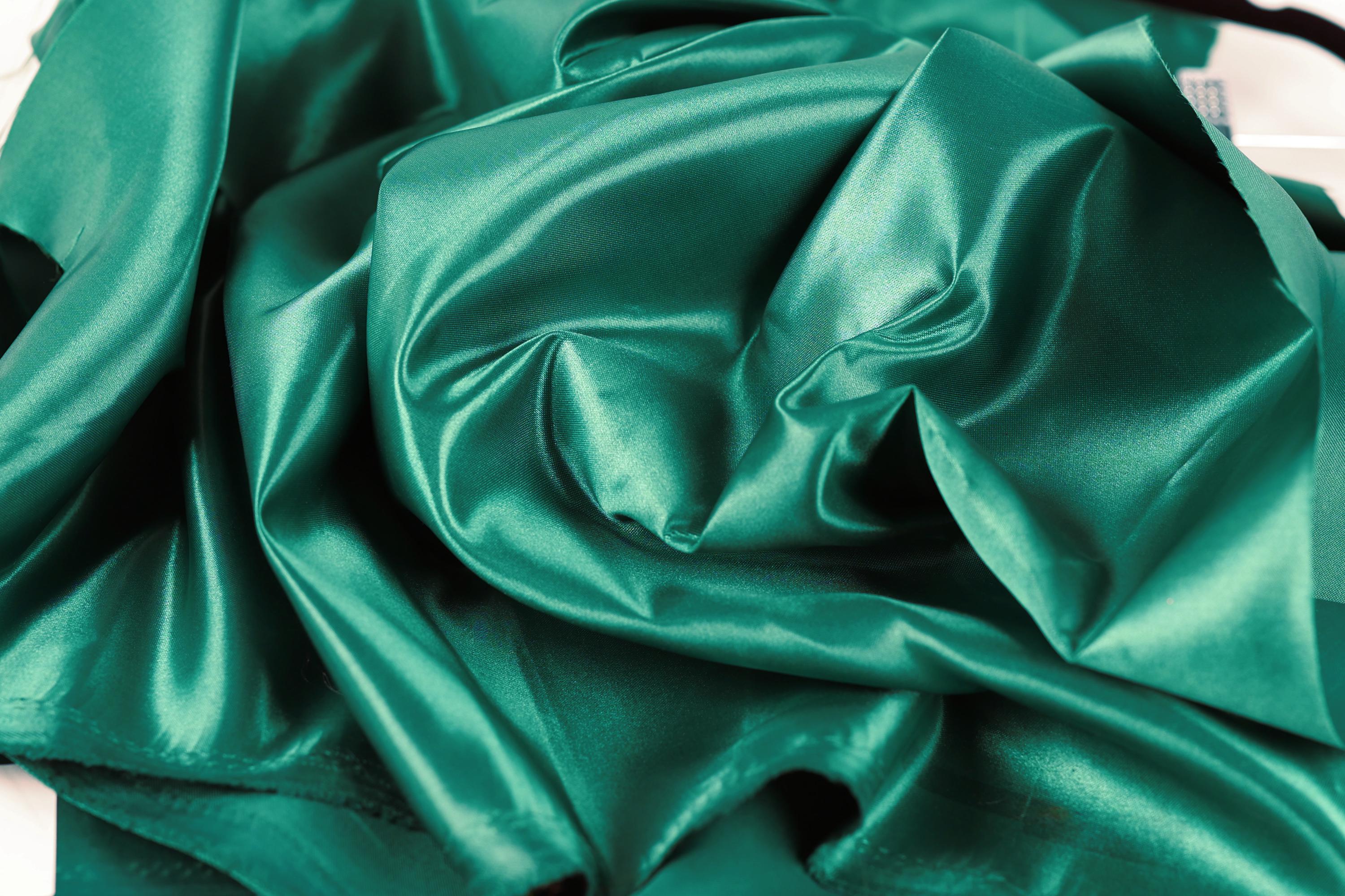 a close-up view of a crumpled, shiny green satin fabric.