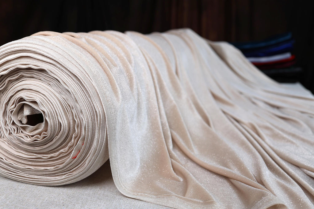 a roll of white fabric sitting on top of a bed
