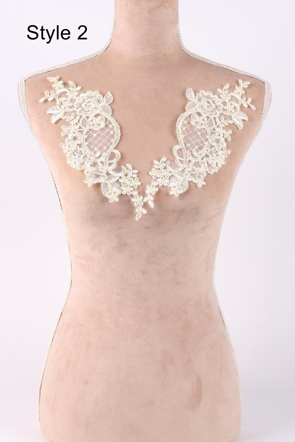 A mannequin with a beige body and white lace details on the shoulders, representing a style or design.