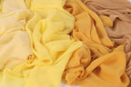 a close-up view of various yellow and beige fabric swatches, with a focus on the textures and colors of the fabrics.