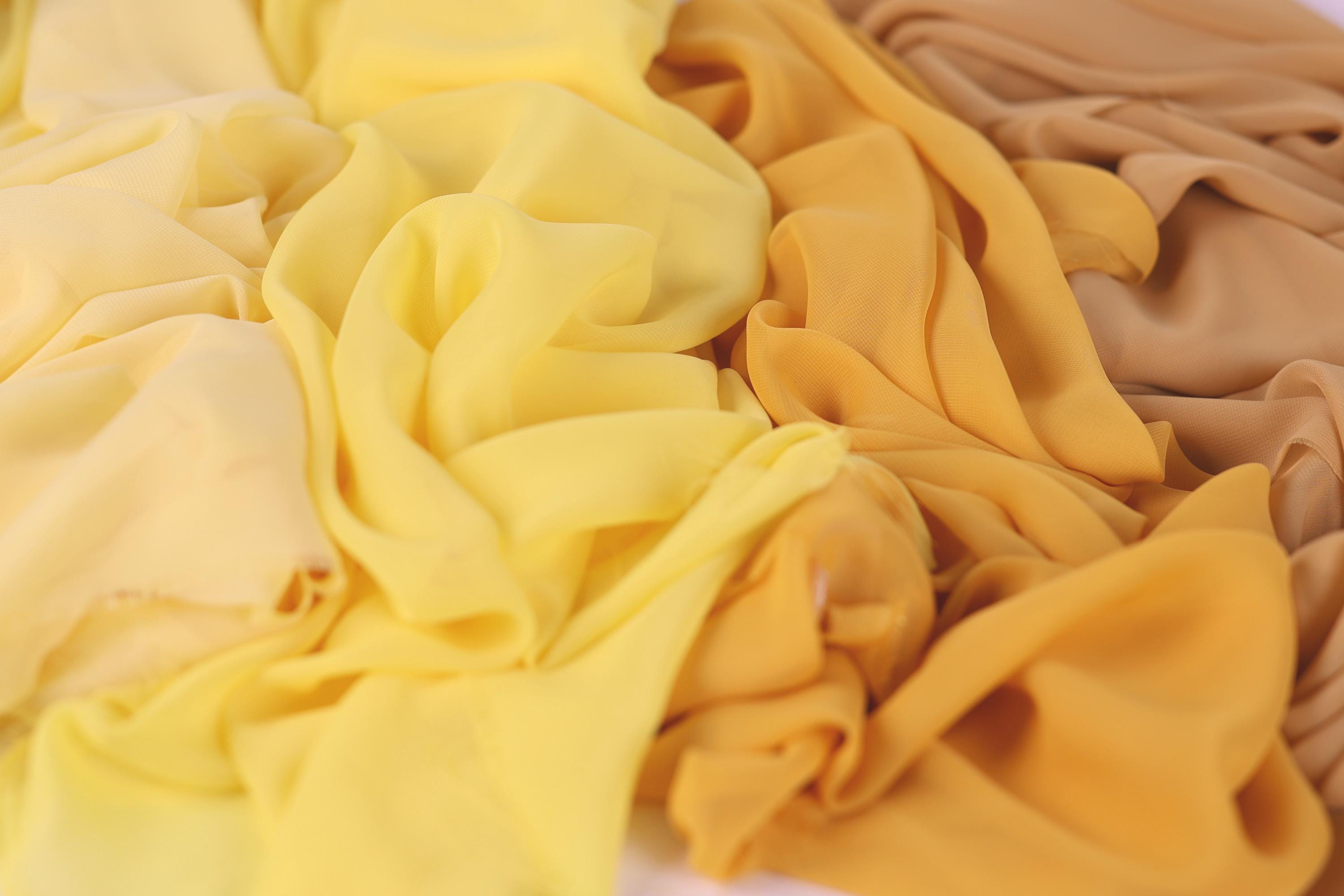 a close-up view of various yellow and beige fabric swatches, with a focus on the textures and colors of the fabrics.