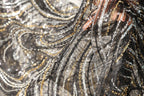 a close-up view of a fabric with a black and gold sequin pattern, creating a visually striking and intricate design.
